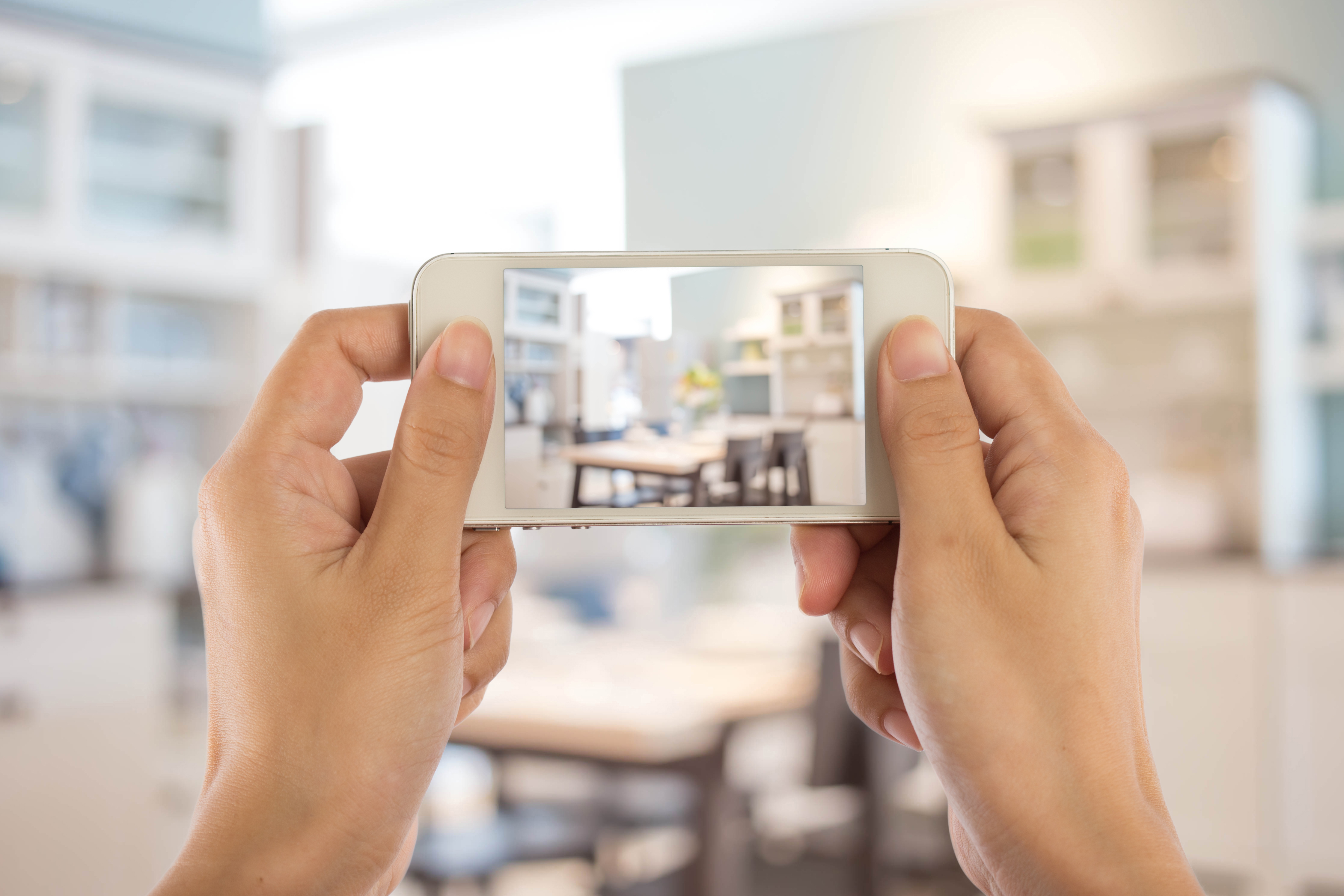 individual taking photo of kitchen with smartphone