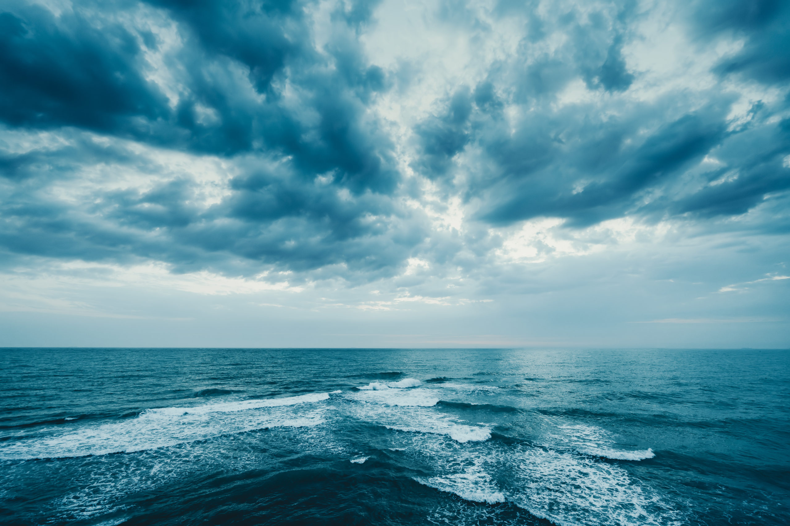 Dark blue clouds and sea with foam waves before a hurricane or tropical storm